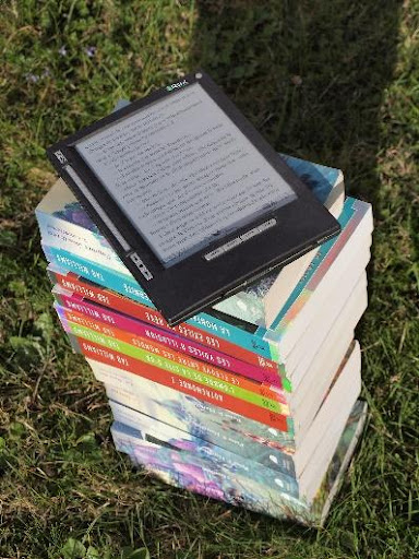 A stack of books with a ereader on top